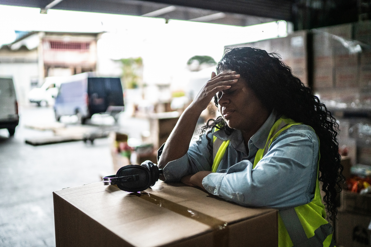 Tired female warehouse worker with heat illness